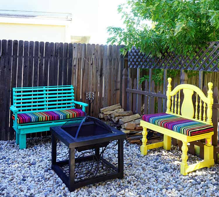 A gravel firepit area with bright teal and yellow seating in a backyard.